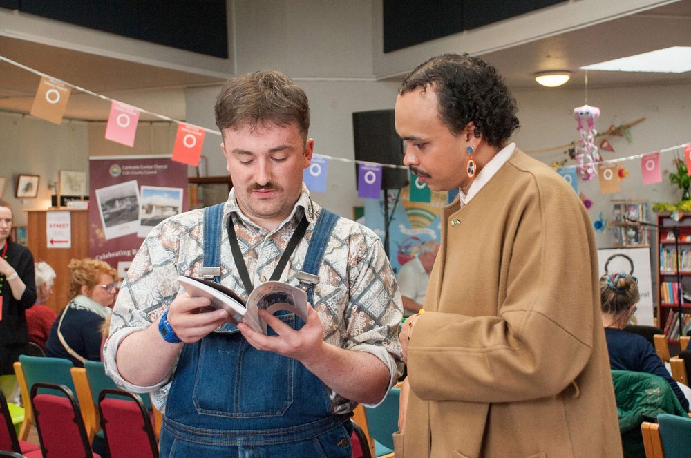 Two men reading a book at an event in Bantry Library