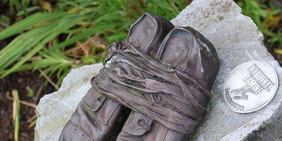 Bronze shoes on a stone as a marker for directions