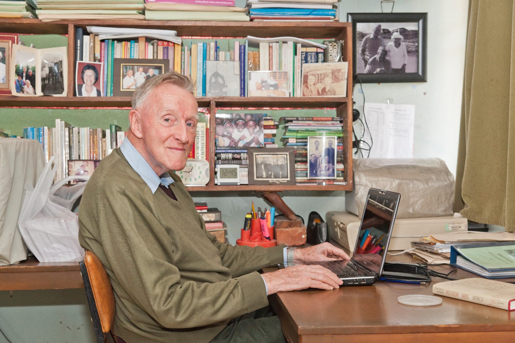 Fr. Kelly sat at a laptop in a library