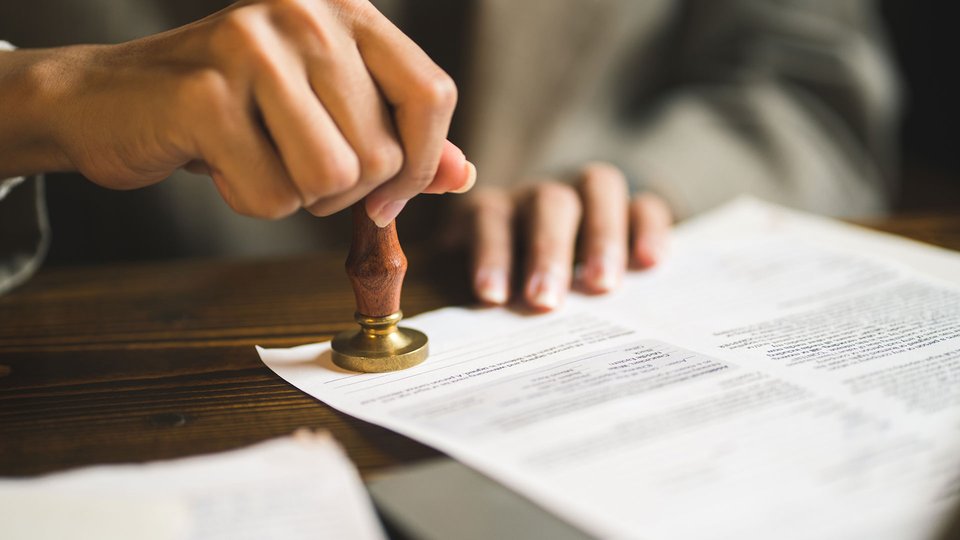 Close up of someone stamping a document
