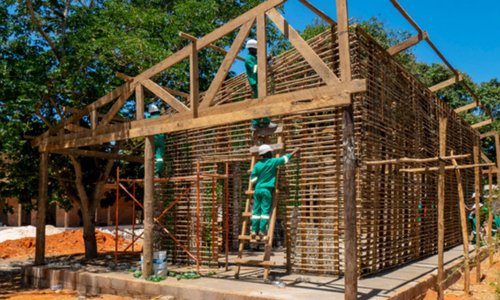 Participants of the Yopipila bioconstruction training on a  bio-constructed building that uses wood and bottles