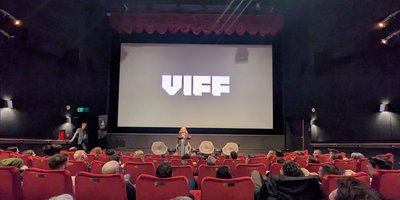 Woman speaking infront of a screen with VIFF written across it