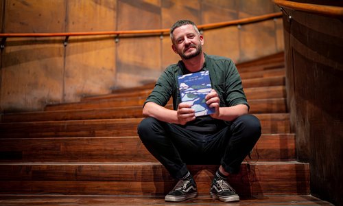David Nash Irish/Chilean poet and artist sitting on stairs