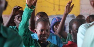 Child raises hand in classroom