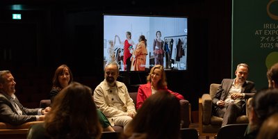 Panel sitting infront of a screen with rotating photos