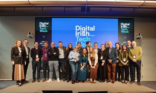 A group of people stood in front of s screen reading 'Digital Irish Tech Week