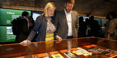 three people standing in an archway holding a sculpture