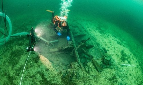 Man diving by a ship wreck