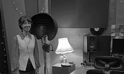 Person singing in front of rainbow lights