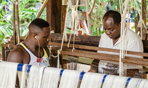 Two men working on a loom