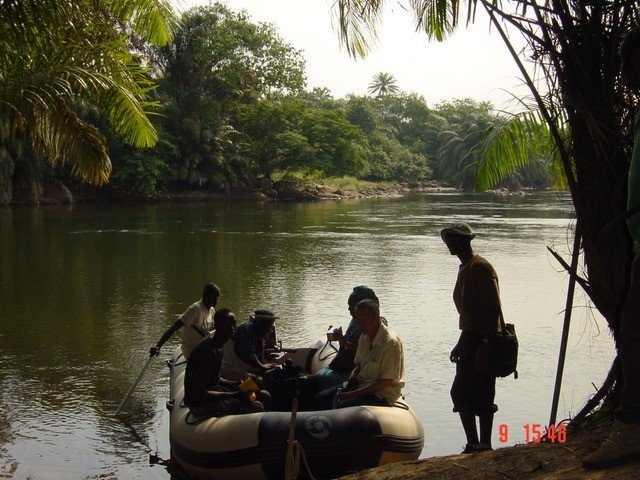 A group of people in a small boat on the shore of an island