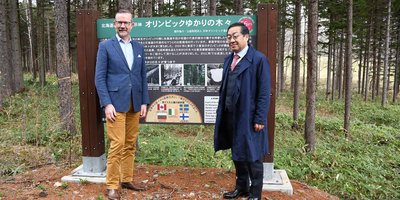 Ambassador of Ireland to Japan Damien Cole smiles with a local official in a pine forest