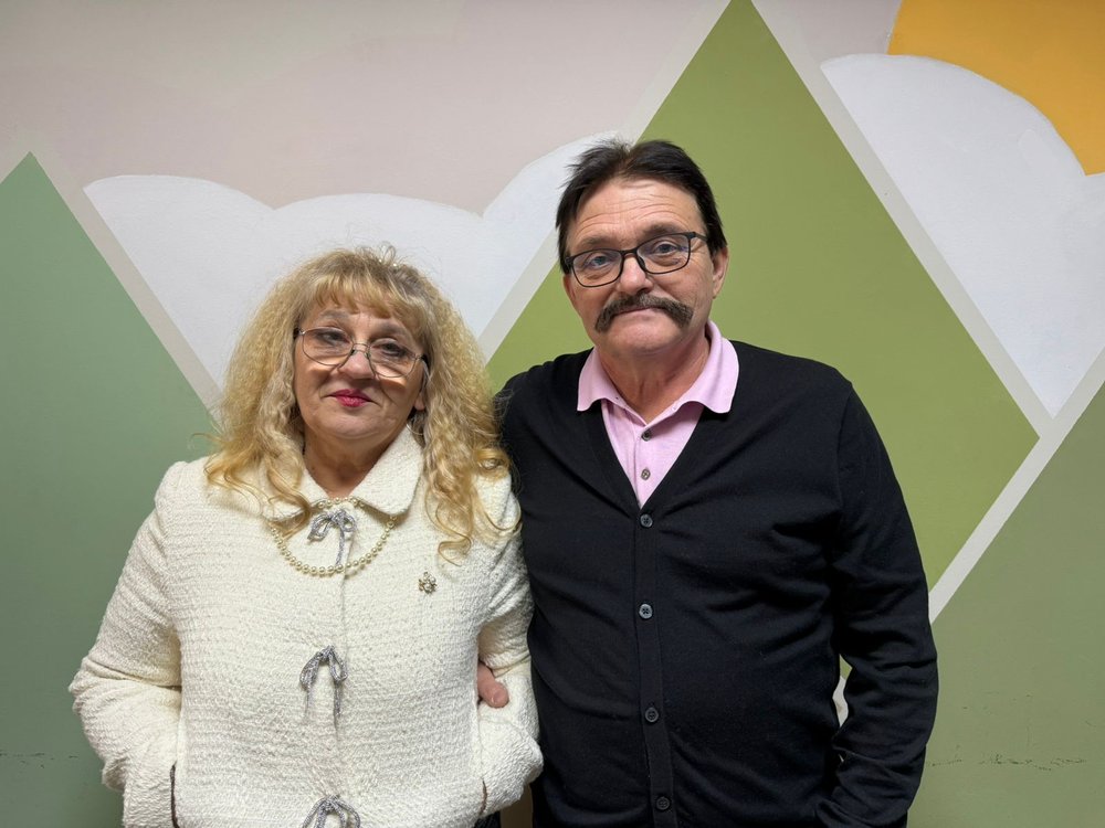 Iryna and Roman stand linking arms