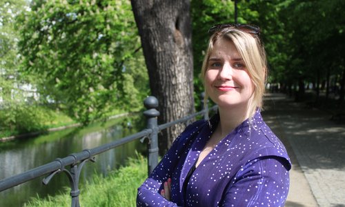 Headshot of a blonde woman wearing purple