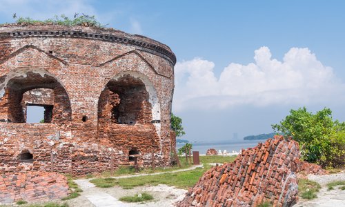 ruins of a round red brick building with arches