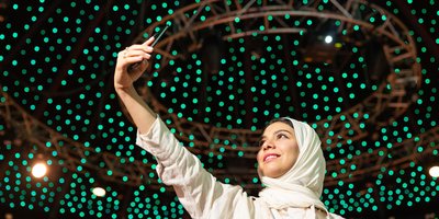 Woman taking a selfie against a backdrop of green lights