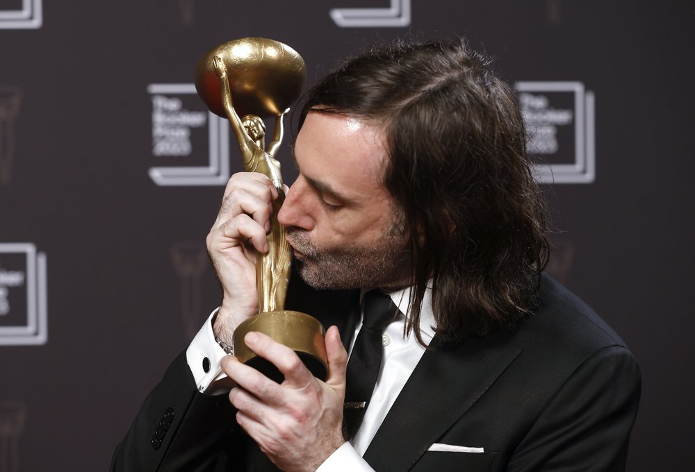 Paul Lynch kissing his Booker Prize trophy