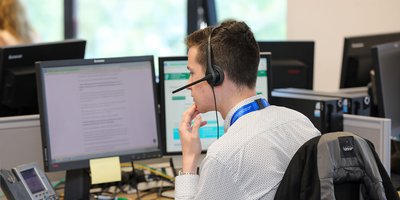 man at computer with headphones