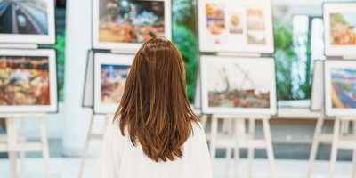 Woman looking at paintings in a gallery