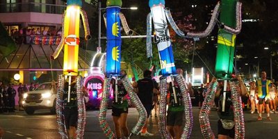 A parade float featuring lit up tubes wrapped in Irish province flags.