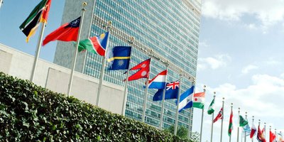 different country flags in front of a large office block