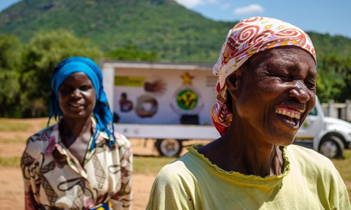 Two women wearing headscarves, laughing