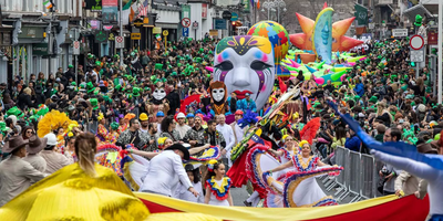 st patrick's day parade with people in colourful costume and a giant mask