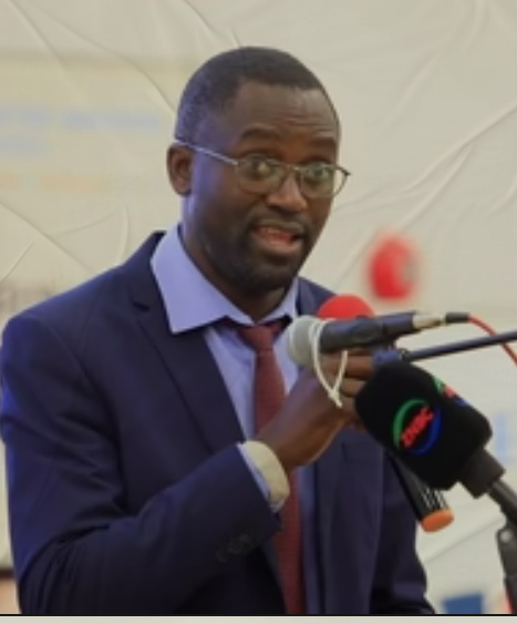Man in suit with tie talking into microphone