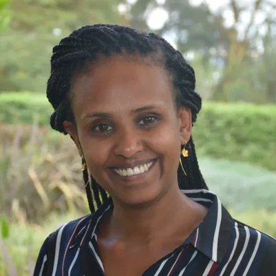 woman smiling in strippy shirt with green background