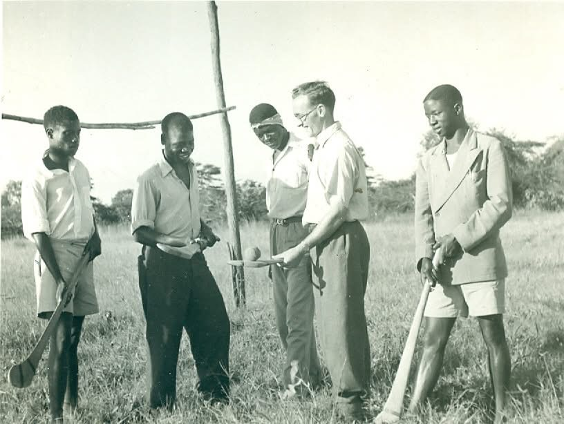 man teaching people how to play hurling