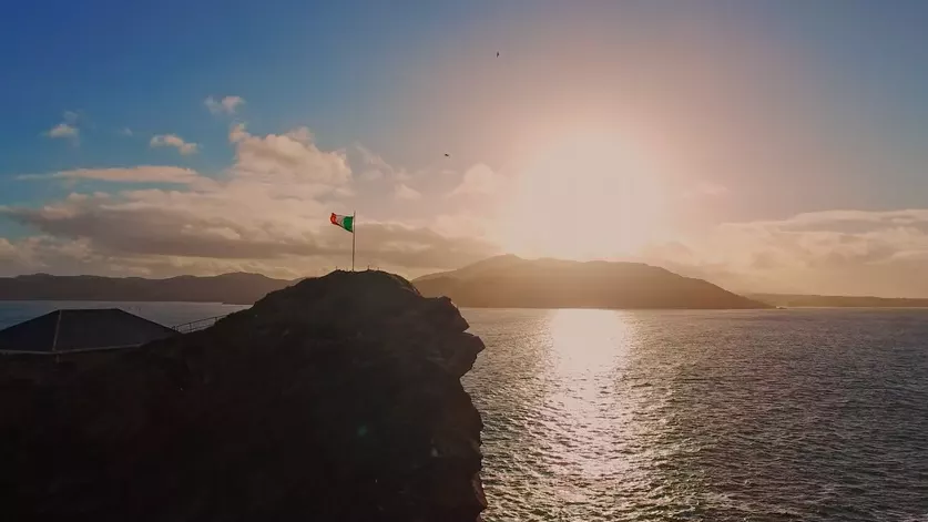 Irish flag on a cliff before the ocean