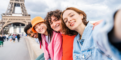Four friends taking a selfie in front of the Eiffel Tower
