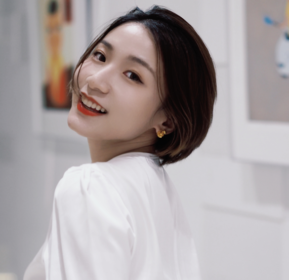 Picture of a Chinese lecturer in Irish studies with paintings hanging on the wall behind.