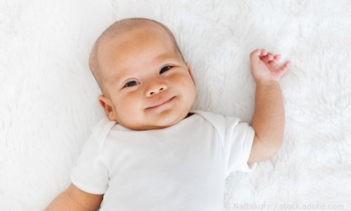 A photo of a baby smiling.