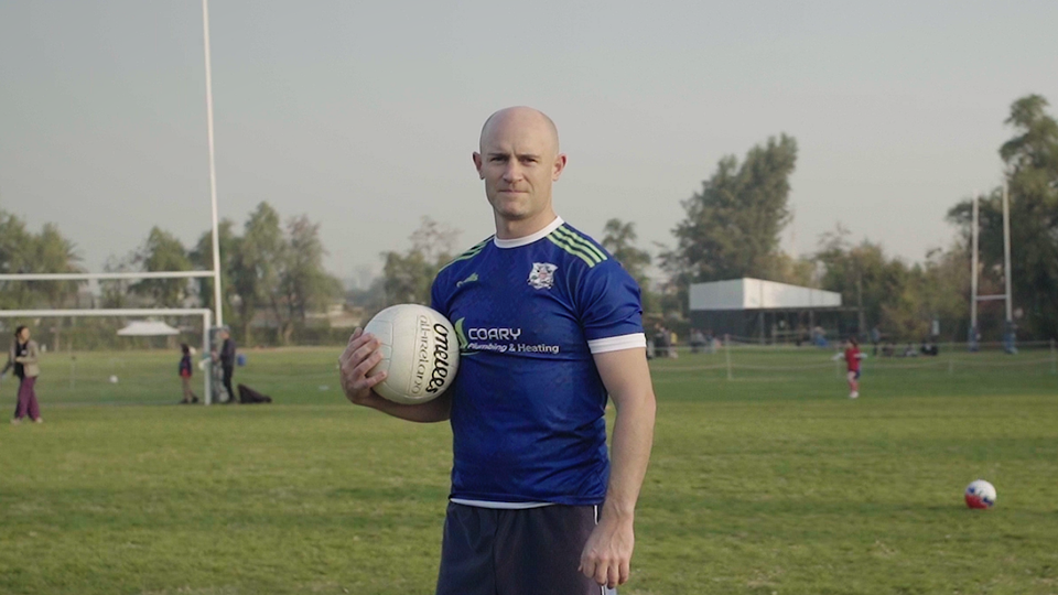 Paddy Coary holding a Gaelic football on a pitch