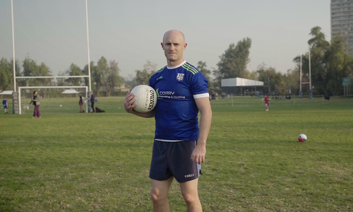 Paddy Coary on a pitch holding a Gaelic Football