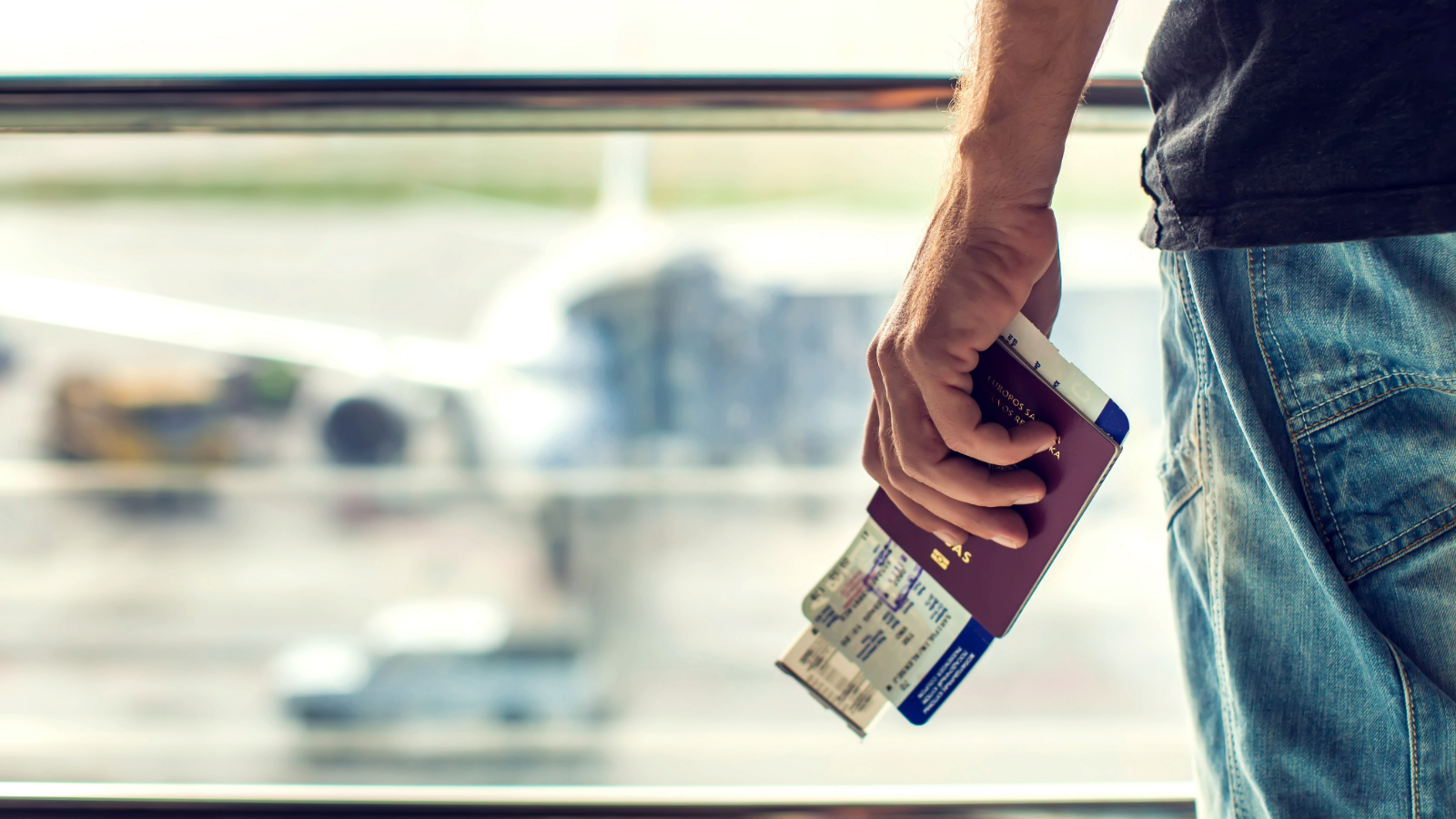 Person holding their passport and boarding card