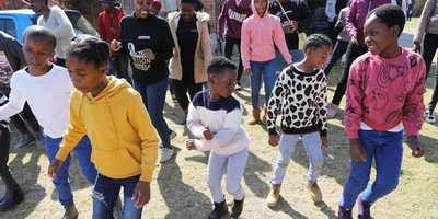 Children in sweaters of different colours dancing.