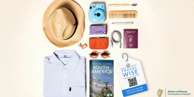 A flatlay of items to pack for a trip, including clothes and other essentials like an Irish passport