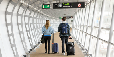 A young couple at Dublin Airport crossing the airbridge with hand luggage