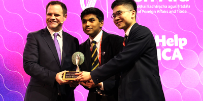 award presentation to students from Minister in front of large screen